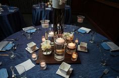 the table is set with candles, plates and napkins for an elegant wedding reception