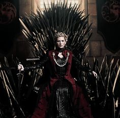 a woman sitting on top of a iron throne