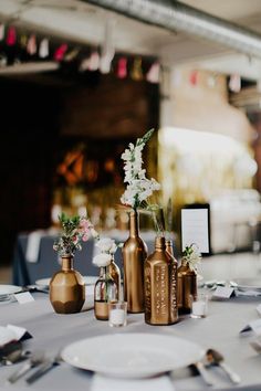 there are three vases with flowers in them on the table at this wedding reception