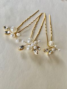 This handmade golden bridal hairpin set is designed for those who appreciate the timeless beauty of pearls but crave a touch of luxury. Whether you're a bride, bridesmaid, or attending a special event, this accessory will add a touch of glamour. Materials: Crafted from different-sized pearls, shiny crystals, and golden wire, attached to the bobby pin.    Design: The set includes three slightly different design pins, allowing you to arrange them creatively in your hair. Each pin features shiny crystals that catch the light beautifully.    Versatile: Perfect for updos, half-up hairstyles, or securing loose waves. It would make a great gift for bridesmaids or flower girls. Wear it on your wedding day, at a formal event, or as a charming accent for a first communion. They are ready to ship in Bridal Hair Pins Pearl, Gold Hair Clips, Crystal Hair Pins, Pearl Hair Pins, Gold Clips, Wedding Hair Pins, Bridal Hair Pins, Half Up Hair, Pearl Set