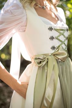 A bridal dirndl is a truly unique, elegant and fashionable way to celebrate your wedding day. Whether you are wearing it for your ceremony, reception or your rehearsal dinner, a made-to-order bridal dirndl is a perfect choice! Available in white or ivory, this bridal dirndl is sure to turn heads at your Oktoberfest-themed wedding Ivory or white satin bridal dirndl Pleated skirt length is 26" from the waist to the hemline 2 skirt pockets Classic square neckline with matching ivory piping Ribbon and chain lace-up bodice Elegant poly chiffon apron with wide ribbon apron ties Pictured with the Sweetheart Blouse with Draped Sleeves in white and Dirndl Petticoat - Last photo pictured with Tulle Top Skirt This dirndl made to order. Please allow 8-10 weeks for delivery Made with love in Chicago, I Oktoberfest Wedding, Bridal Dirndl, Wedding Dirndl, Square Necklines, Rehearsal Dinners, Square Neckline, White Wedding, Ideias Fashion, Vogue