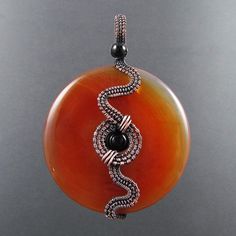 Snake Wrapped Donut Pendant Wirework by WireJewelryTutorials Donut Jewelry, Wire Pendants, Wire Wrap Jewelry Designs, Donut Pendant, Wire Wrapped Jewelry Tutorials, Wire Jewelry Tutorial, Wire Jewelry Designs, Wire Wrapping Stones, Wire Work Jewelry