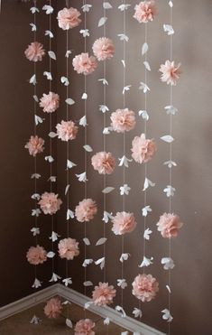 some pink flowers hanging from the ceiling in a room with dark walls and flooring