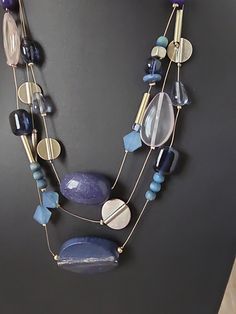 Elevate your style with this stunning Chico's necklace that exudes a boho vibe perfect for any occasion. The necklace features a mix of blue and clear glass beads, acrylic stones, and a floating/keepsake pendant shape that adds a unique touch to your look. The lobster closure and adjustable ball/bead chain make it easy to wear, while the 18-inch length and multi-strand layer design add a touch of elegance. This vintage necklace is perfect for females who want to add a pop of color to their outfit. The necklace is signed and comes with a seller warranty for your peace of mind. Don't miss out on this beautiful piece of jewelry that will surely make a statement. Blue Bohemian Jewelry With Large Beads, Blue Bohemian Necklace For Jewelry Making, Blue Bohemian Beaded Necklace With Faceted Beads, Bohemian Blue Beaded Necklace With Faceted Beads, Bohemian Blue Necklaces With Natural Stones, Blue Long Necklace With Natural Stones For Gift, Blue Long Necklace With Natural Stones As Gift, Bohemian Long Glass Necklace, Adjustable Blue Costume Jewelry Necklace