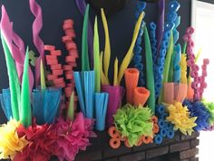 there are many different colored sticks on the fireplace mantels that have been made out of plastic straws