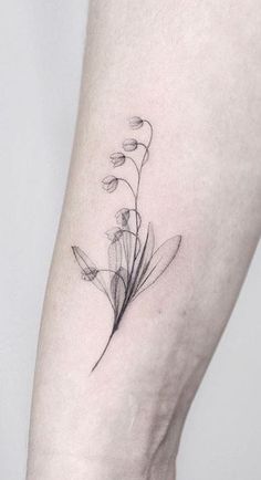 a single flower tattoo on the left ankle is shown in black and grey ink, with thin lines running through it