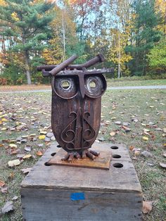 an owl sculpture sitting on top of a wooden box