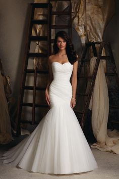 a woman in a wedding dress posing for the camera