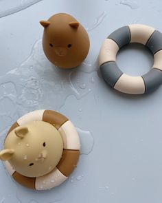 two toy animals sitting next to each other on top of a blue surface with water