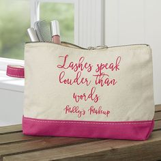 a pink and white zippered pouch with writing on it that says lashes speak, cuddle than words