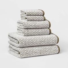 six folded towels stacked on top of each other in white and brown geometric print,