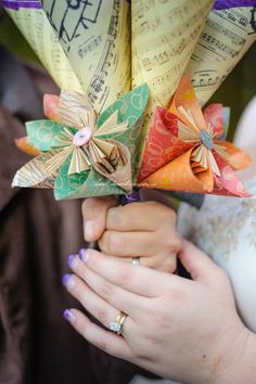 a woman holding an origami flower bouquet in her hands with music notes on it