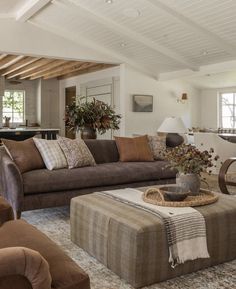 a living room filled with furniture and lots of pillows on top of it's couches