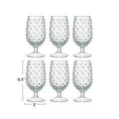 four clear wine glasses are shown with measurements for each one, and the glass has an intricate