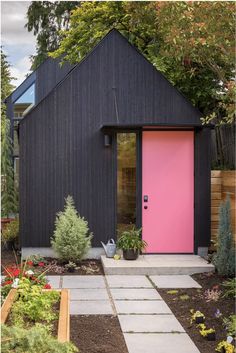 a pink door in front of a black house