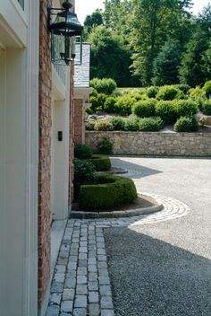 a brick building with a stone pathway between it and a light pole on the side