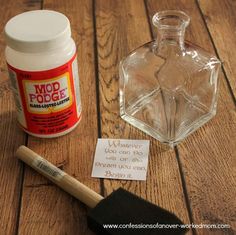 a wooden table topped with a bottle of glue and an empty jar next to it