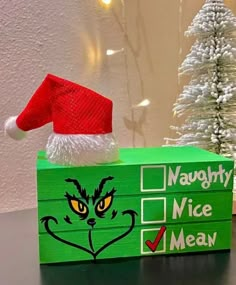 a green box with a grin face on it and a red santa hat sitting on top of it