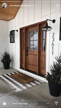 the front door of a house with two potted plants and a welcome mat on the porch