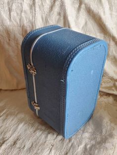 a blue suitcase sitting on top of a bed