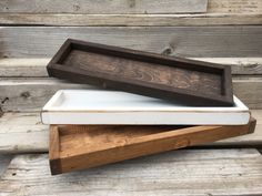 two wooden trays sitting on top of each other