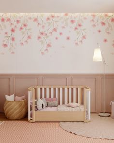 a baby's room with pink flowers on the wall