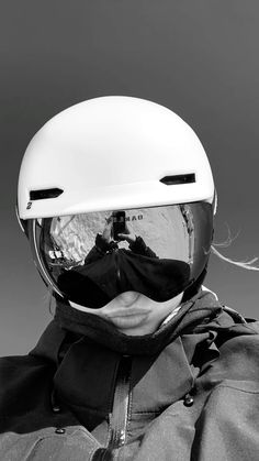 black and white photograph of a person wearing a snowboard helmet