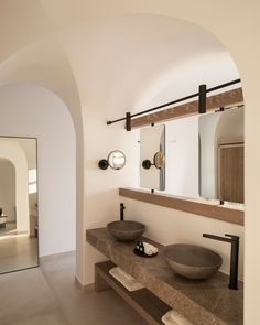 a bathroom with two sinks and mirrors in it