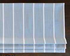 a blue and white striped curtain on top of a wooden table