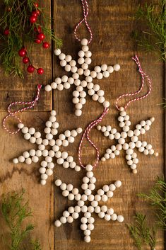 a wooden table topped with white snowflakes and christmas decorations on top of it