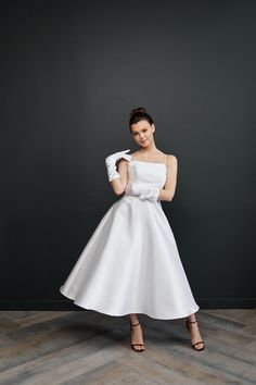 a woman in a white dress posing for the camera