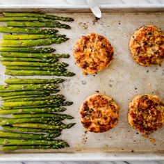 asparagus and crab cakes on a baking sheet