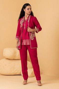 Fuchsia chanderi jacket with placement floral, wreath pattern, contrast zari, thread, sequin and pearl embroidery. Paired with short top with zari striped panels and straight pant.
Components: 3
Pattern: Embroidered
Type Of Work: Thread, Sequin, Zari and Pearl Work
Neckline: Jacket: Open, Top: V Collar
Sleeve Type: Jacket: Three Quarter Sleeves
Fabric: Jacket: Chanderi, Top and Pant: Modal Satin
Color: Fuchsia
Other Details: 
Attached lining
Length:
Jacket: 30 inches
Sleeves: 18 inches
Top: 29 i Elegant Pink Outerwear For Festive Occasions, Elegant Pink Festive Outerwear, Festive Pink Workwear Sets, Pink Festive Workwear Sets, Traditional Festive Blazer For Workwear, Traditional Festive Outerwear For Work, Pearl Work, Pearl Embroidery, Cord Set