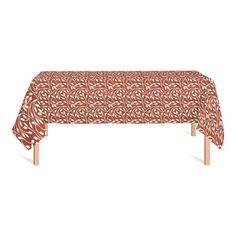 an orange tablecloth with white circles on it and wooden legs in front of a white background