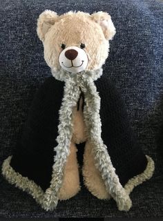 a teddy bear wearing a scarf and sitting on a chair