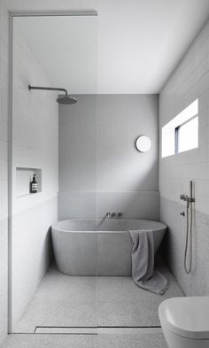 a bathroom with a bathtub, toilet and shower head in the middle of it