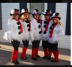 four people dressed up in costumes posing for a photo outside the house with their mouths open