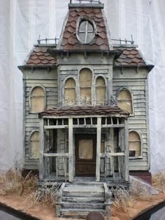 an old doll house on display in front of a white backdrop