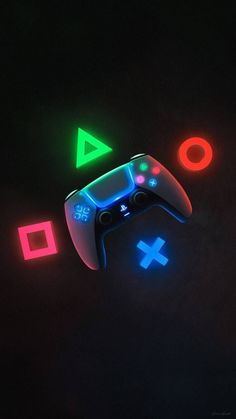 a video game controller glowing in the dark with neon colors on it's side