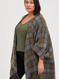 a woman wearing a plaid ponchy with fringes