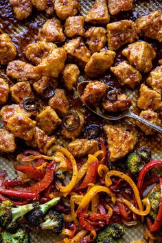 chicken, broccoli and peppers on a tray with tongs