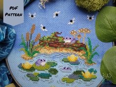 Froggo Pond - a whimsical cross stitch pattern that you can stitch of some frogs hanging out among lilypads, cattails, a moss covered log, and fireflies!  There's opportunities to customize your stitching experience with this pattern by changing the colors of the frogs (color palettes included) or even adding glow in the dark floss for the fireflies.  This design was stitched on hand-dyed aida in a two-tone.  Half of the fabric is dark blue, and the other half light blue.  Included in this listi Frog Cross Stitch, Cottagecore Embroidery, Frog Pond, Cottagecore Art, Frog Gifts, Landscape Digital, Cross Stitch Finishing, Needle Point, Stitching Art