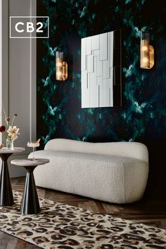 a living room with black and white walls, leopard print rug and two round tables