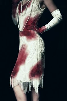 a woman in a dress with red and white paint on it