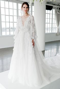 a woman in a wedding dress standing on a white platform