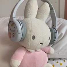 a stuffed animal with headphones on sitting on a bed