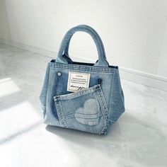 a denim bag with a pocket on the inside is shown in front of a white wall