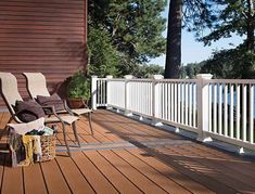 two chairs sitting on a wooden deck overlooking the water