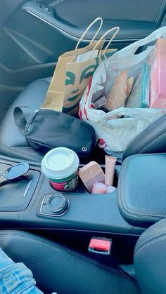 a car filled with lots of items including shopping bags and other personal care products sitting in the passenger seat