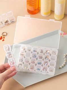 a person is holding an assortment of jewelry in their hand while sitting at a table